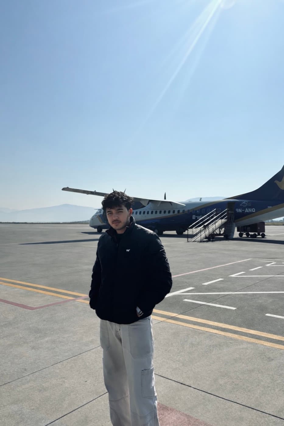 Shubham Khurana standing beside an aircraft in the mountains